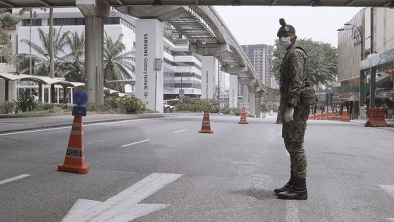 Seorang petugas keamanan sedang memantau jalan raya di Kuala Lumpur saat lockdown diberlakukan di Malaysia pada 1 Juni 2021. (BERNAMA)